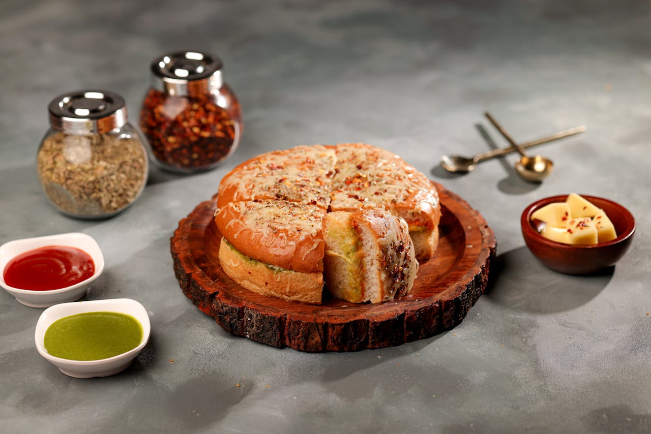 Tasty stuffed bread served with sauces and spices on a wooden platter, perfect for savory food lovers.