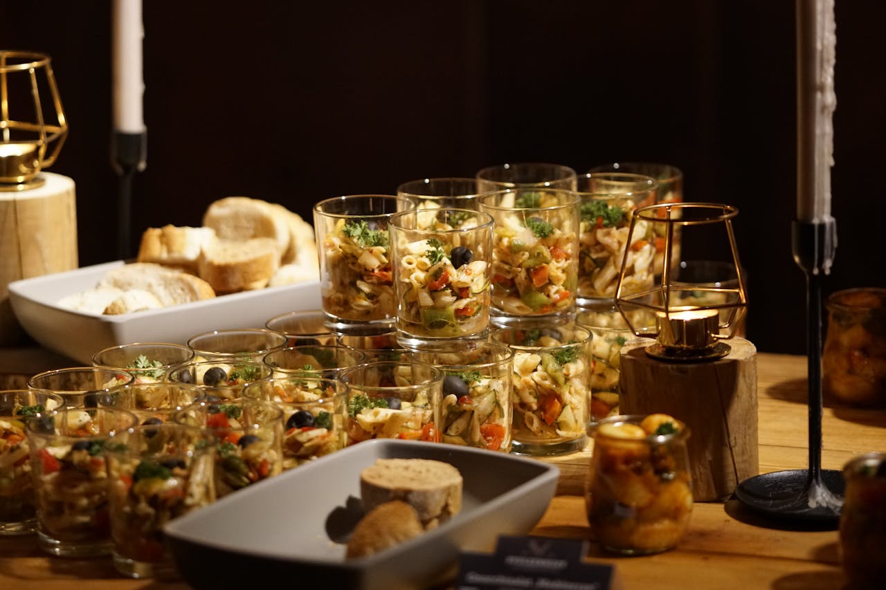 A beautifully arranged table featuring pasta appetizers in glass cups, perfect for events.
